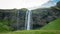 Gljufrabui waterfall with unidentifed tourists nearby in Iceland