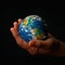 Global awareness hand holding globe on black background