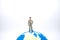 Global Business and Planning concept. Close up of businessman miniature figure standing on mini world ball on white background and