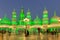 Global Village amusement park at night with green illuminated arabic style towers and domes.