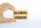 Global vision symbol. Wooden blocks with words `Global vision` on beautiful white background. Businessman hand. Business and