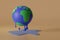 Global warming climate change concept: melting earth on orange background. 3d illustration
