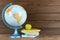 Globe, books and fresh apple on wooden table, space for text. Geography lesson