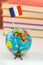 Globe icon the Eiffel Tower on the background of books and textbooks. Learn French. French language courses, practice in France.