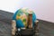 Globe with inscriptions in cyrillic. Around him are spent batteries, covered with corrosion. World Environment Day. Recycling and