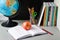 Globe, notebook stack, pencils and  apple on the table. Schoolchild and student studies accessories. Back to school concept