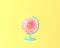 Globe sphere orb pink flower concept on pastel yellow background
