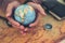 Globe, whole world in hands and compass, magnifying glass and book on route map on the table. Travel , Adventure and Discovery