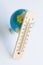 Globe and wooden eco-friendly thermometer on white background. Temperature in Celsius and Fahrenheit. White background. Concept of