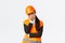 Gloomy and bothered asian female engineer tired of working, wear safety helmet and reflective jacket, lean on palm and