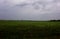A gloomy cloudy sky over a green field