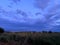 Gloomy cloudy sky at sunset. The moment before the storm. Picturesque grassy field. Nizhny Novgorod region, Russia.