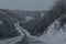 Gloomy grey empty winter road in the hills.