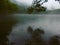 Gloomy lake in rainy day. Foggy scene