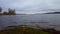 Gloomy lake under overcast sky in summer day. Cloudy skies over murky lakeside landscape view