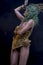 Gloomy Latin woman with green hair and gold costume with handmade flourishes, fantasy image and tale