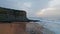 Gloomy marine beach landscape at cloudy day. Sandy coast with calm ocean waves