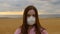 Gloomy portrait of a lonely girl in a mask on the beach during a pandemic