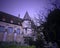 Gloomy twilight medieval castle with garden