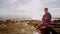 Gloomy young man on a beach with a tablet pc and a credit card