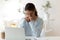 Gloomy young woman sitting at desk looking at computer screen