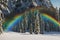 Glorious rainbow in stormy skies over snowy mountains like the Swiss Alps