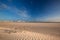 Glorious sand dune in the distance over empty tidal lagoon