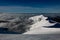 glorious view of the snow-covered mountain range surrounded by clouds and clear blue sky