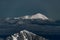 glorious view of snow covered mountain top and picturesque winter mountain landscape with coniferous trees and fog