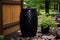 Glossy Black rain barrel sitting outside. Generate ai