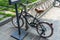 Glossy black vintage bicycle parks at the bicycle park with anti-theft bike lock cable hook up to the stainless bar