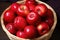 glossy red apples arranged neatly in a woven basket