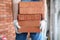 Gloved builder manually carries brick construction