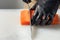 A gloved chef cuts salmon fillets on a large white Board