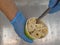 A gloved confectioner puts rolls of ice cream in a bowl