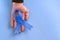 Gloved doctor`s hand holding blue ribbon on blue background with copy space. Colorectal Cancer Awareness. Colon cancer in an