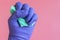 Gloved hand with washcloth on pink background. Rubber gloves and a washcloth for cleaning on a pink background. Set of rubber