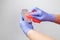 Gloved hands cleaning a can of preserves after grocery shopping, to prevent the spread of the coronavirus