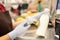 Gloved hands of female cashier in uniform scanning bottle of milk over counter