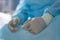 Gloved hands of tired professional surgeon sitting in operating room at break