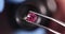 Gloved jeweler holds pink gemstone tweezers and examines through magnifying glass 4k movie