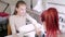 A gloved manicurist woman in a beauty salon nails a client with a nail file before applying a gel coating.