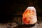 Glow salt lamp, dark vintage wooden background, selective focus