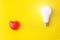 Glowing bulb and red heart on yellow background, uniqueness concept. Idea, innovation, creativity concept, design template, copy