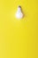 Glowing bulb on yellow background, uniqueness concept. Idea, innovation, creativity concept, design template, copy space