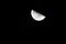 Glowing crescent moon illuminated in the inky-black night sky