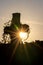 Glowing cross silhouette with sunbeams sunset sunlight and clear evening sky shows christianity spirituality of church and forgive