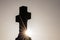 Glowing cross silhouette with sunbeams sunset sunlight and clear evening sky shows christianity spirituality of church and forgive