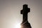 Glowing cross silhouette with sunbeams sunset sunlight and clear evening sky shows christianity spirituality of church and forgive