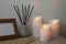 Glowing decorative LED candles on wooden table indoors